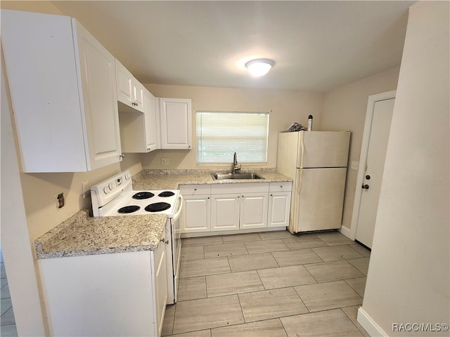 kitchen with white cabinetry, light stone counters, white appliances, and sink