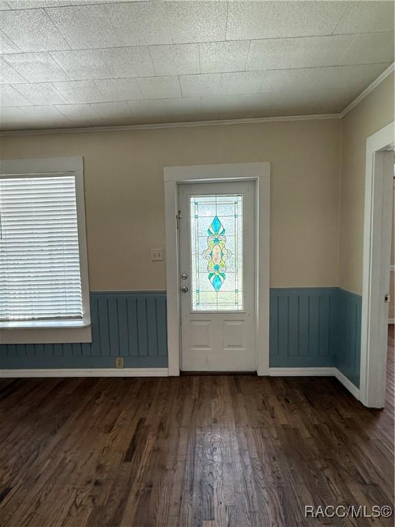 entrance foyer featuring dark hardwood / wood-style floors and crown molding