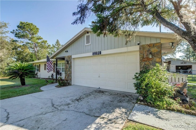 2191 S Moonlit Pt, Homosassa, FL 34448 - ranch-style house with stone siding, a garage, driveway, and fence