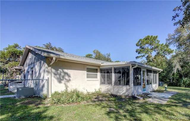 2191 S Moonlit Pt, Homosassa, FL 34448 - view of side of property featuring a sunroom, stucco siding, and cooling unit