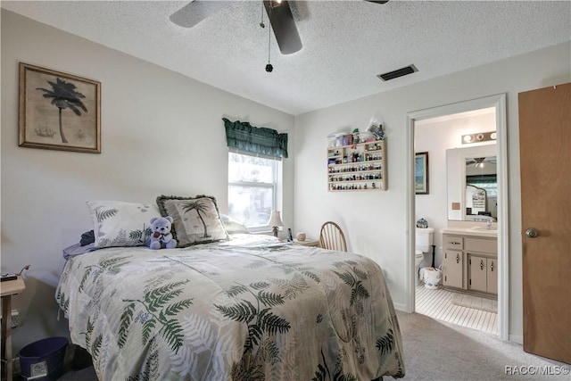 2191 S Moonlit Pt, Homosassa, FL 34448 - bedroom with light carpet, a sink, ensuite bath, a textured ceiling, and a ceiling fan