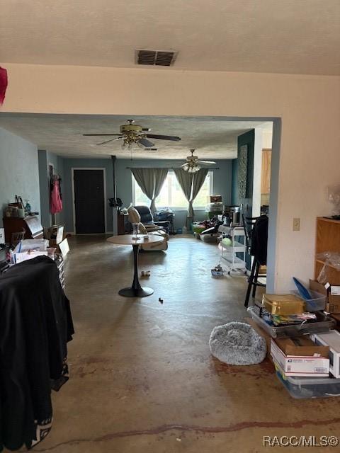 miscellaneous room with concrete floors, visible vents, and a ceiling fan