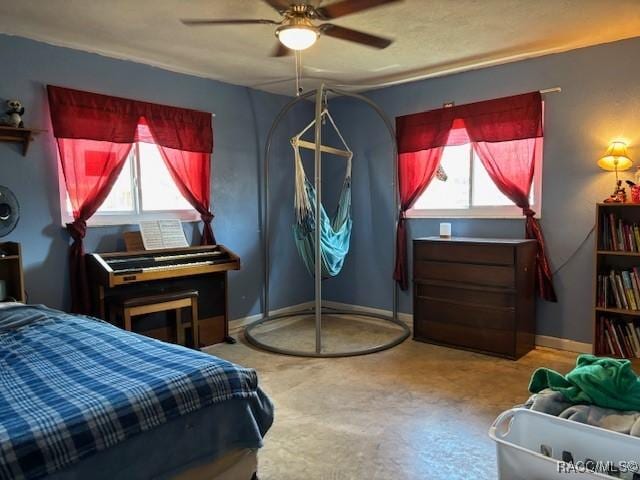 bedroom featuring ceiling fan and baseboards