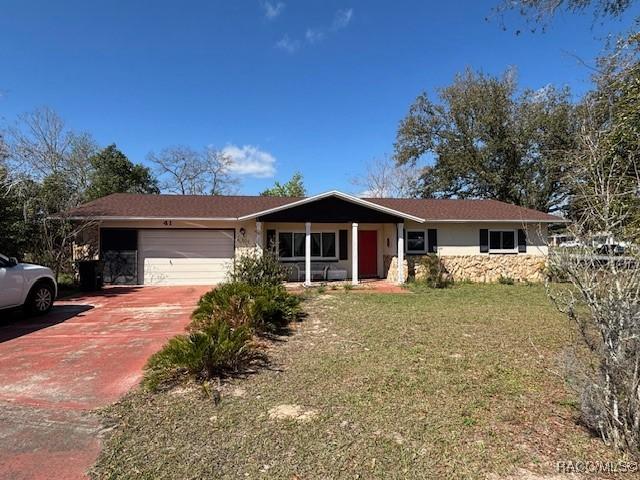 ranch-style house featuring an attached garage, driveway, and a front lawn