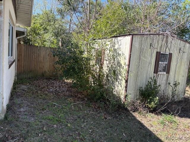 view of yard with a storage unit, an outdoor structure, and a fenced backyard