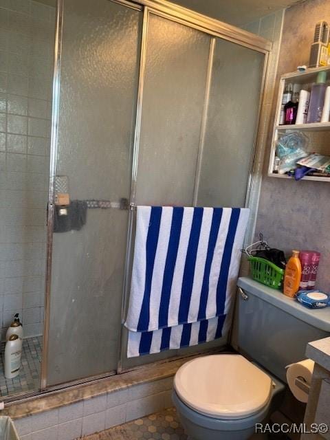 bathroom with toilet, a stall shower, and vanity