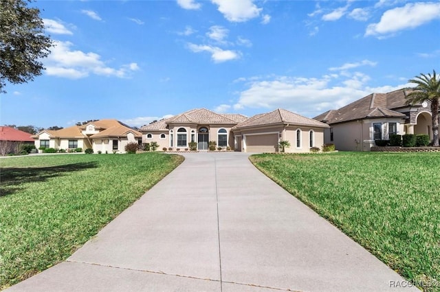 mediterranean / spanish home with concrete driveway, a front lawn, an attached garage, and stucco siding