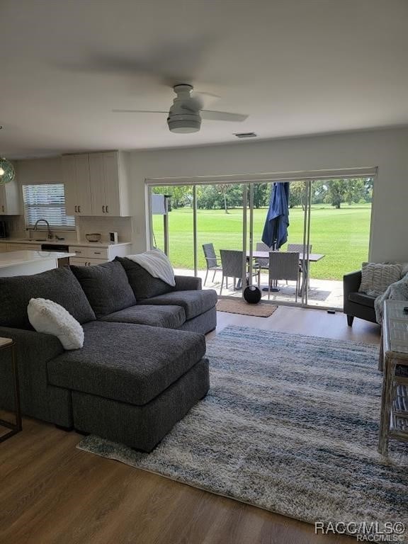 living room featuring wood-type flooring and ceiling fan