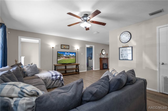 living room with light hardwood / wood-style flooring and ceiling fan