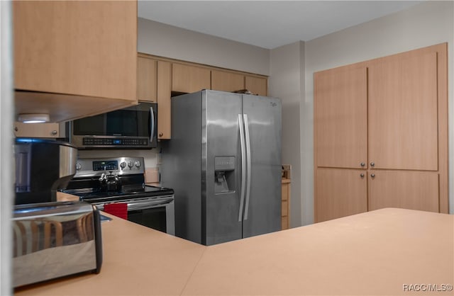 kitchen with light brown cabinetry and stainless steel appliances