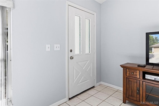foyer entrance with light tile patterned floors and baseboards