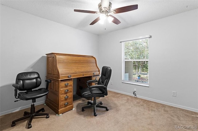 office space with baseboards, ceiling fan, and light carpet