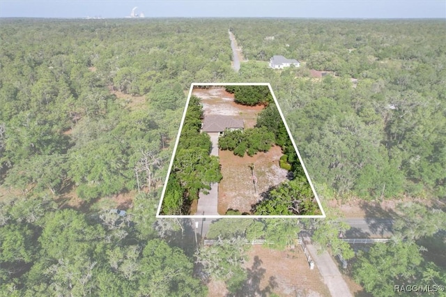 birds eye view of property with a view of trees