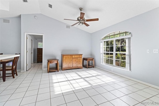 unfurnished room featuring a ceiling fan, visible vents, vaulted ceiling, light tile patterned floors, and baseboards