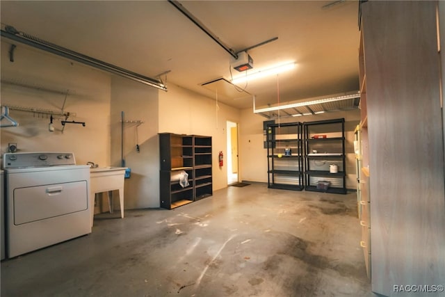 garage featuring a garage door opener, washer / dryer, and sink