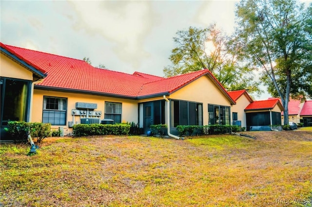 view of front of home featuring a front yard and a sunroom