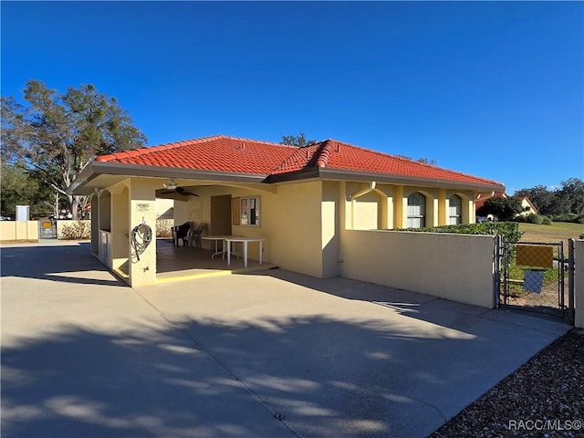 view of property exterior with ceiling fan and a patio