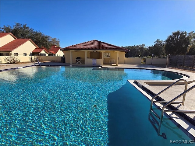 view of swimming pool featuring ceiling fan and a patio