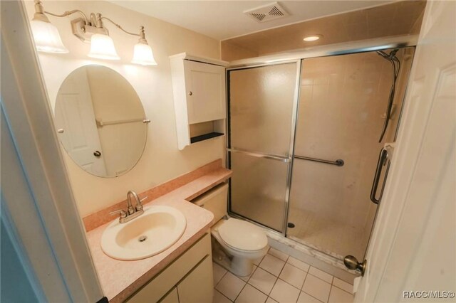 bathroom featuring vanity, tile patterned floors, toilet, and walk in shower