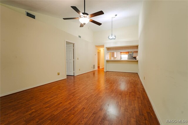 unfurnished living room featuring high vaulted ceiling, hardwood / wood-style floors, and ceiling fan