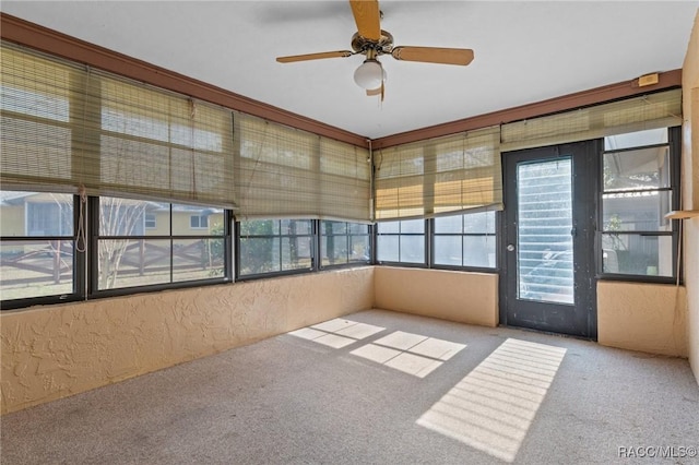 unfurnished sunroom featuring ceiling fan