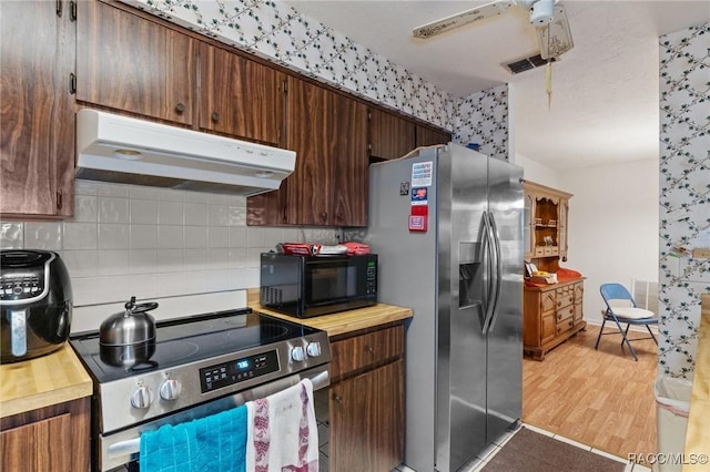 kitchen featuring backsplash, ceiling fan, light wood-type flooring, and appliances with stainless steel finishes