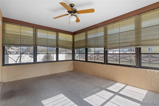 unfurnished sunroom with ceiling fan