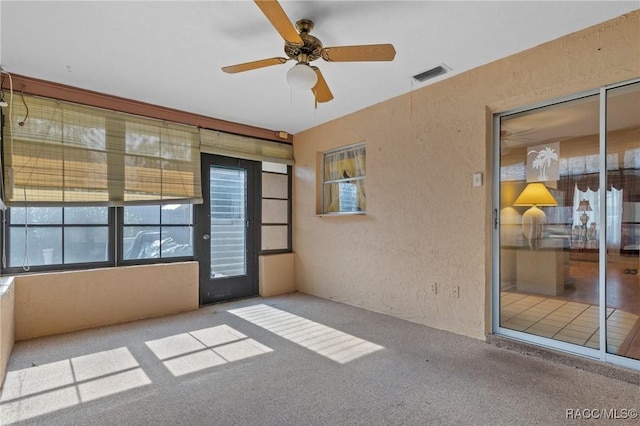 unfurnished sunroom featuring ceiling fan