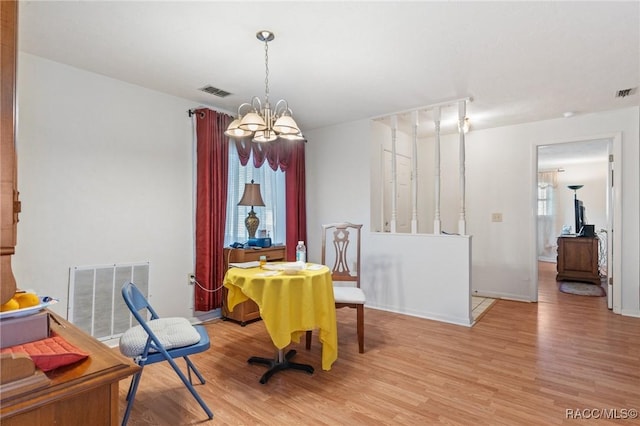 dining area featuring light hardwood / wood-style flooring and an inviting chandelier