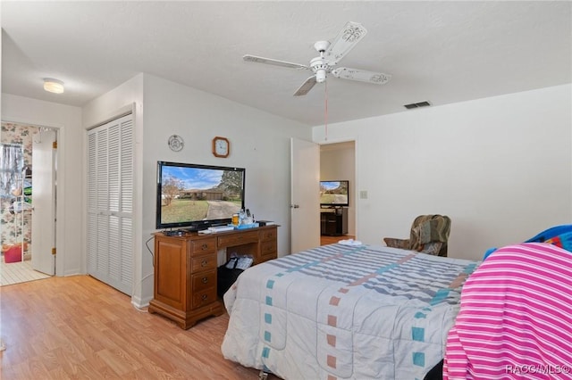 bedroom with ceiling fan, light hardwood / wood-style floors, and a closet