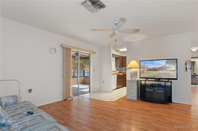 living room featuring light hardwood / wood-style flooring and ceiling fan