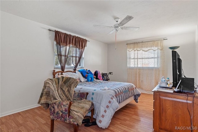 bedroom with ceiling fan and light wood-type flooring