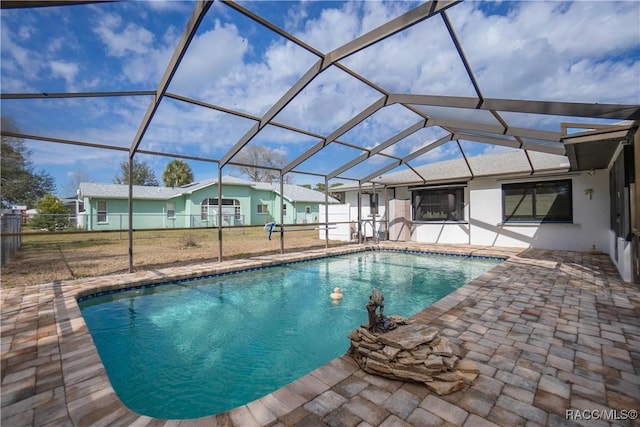 view of pool featuring glass enclosure and a patio