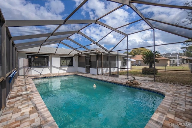 view of pool featuring glass enclosure, a patio, and pool water feature