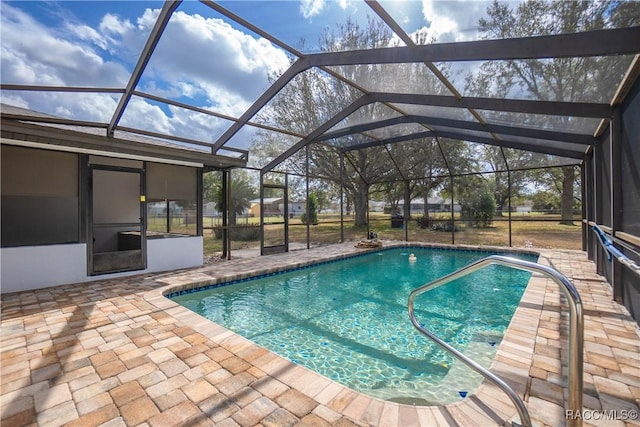 view of swimming pool featuring a patio and a lanai