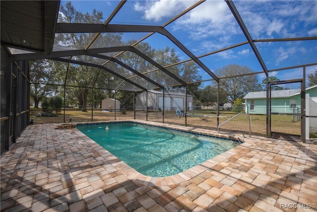 view of swimming pool featuring a patio, a storage unit, and a lanai