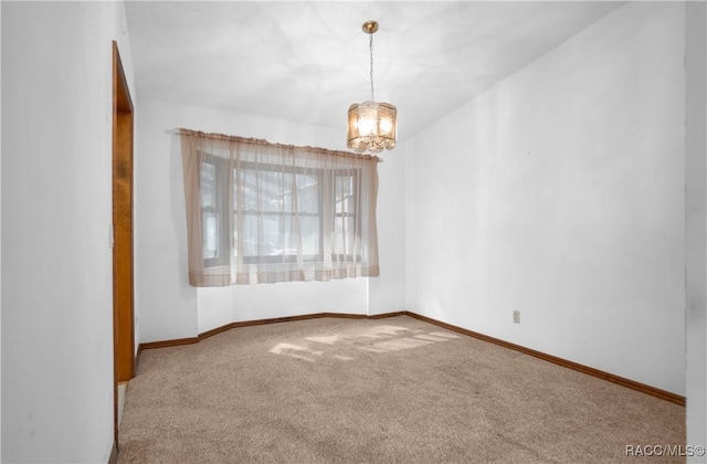 unfurnished room with carpet floors and a notable chandelier