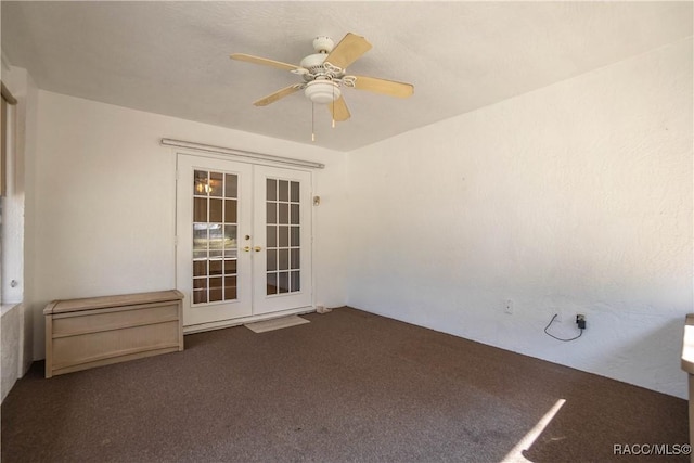 carpeted spare room featuring french doors and ceiling fan