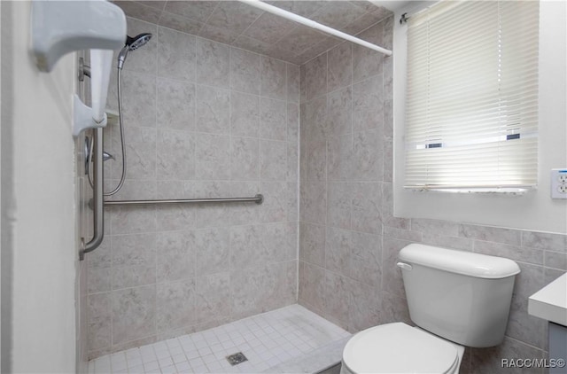 bathroom with vanity, tiled shower, and toilet