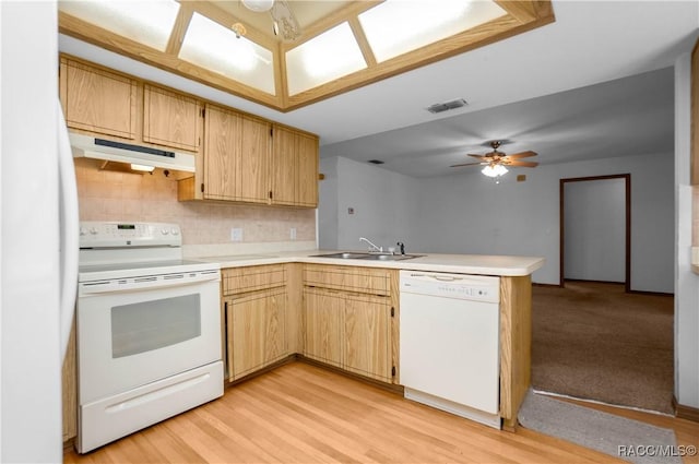 kitchen with white appliances, sink, backsplash, light wood-type flooring, and kitchen peninsula