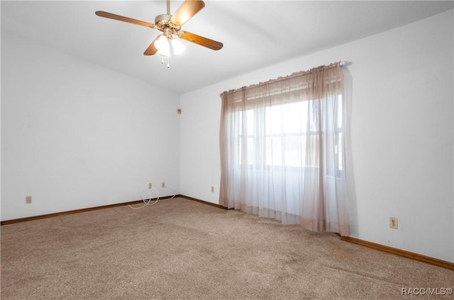 carpeted spare room featuring ceiling fan and vaulted ceiling