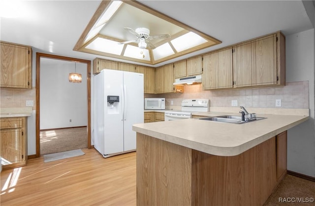 kitchen featuring white appliances, pendant lighting, backsplash, sink, and kitchen peninsula