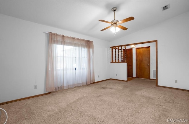 carpeted spare room featuring lofted ceiling and ceiling fan