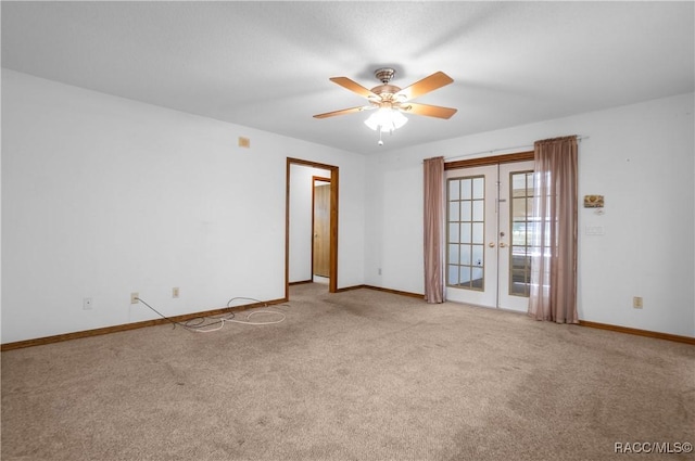 carpeted spare room with ceiling fan and french doors