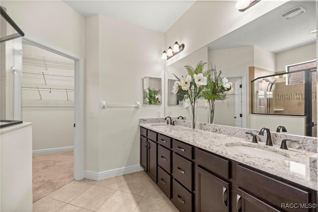 1825 W Caroline Path, Lecanto, FL 34461 - bathroom with double vanity, a shower stall, a spacious closet, and tile patterned floors