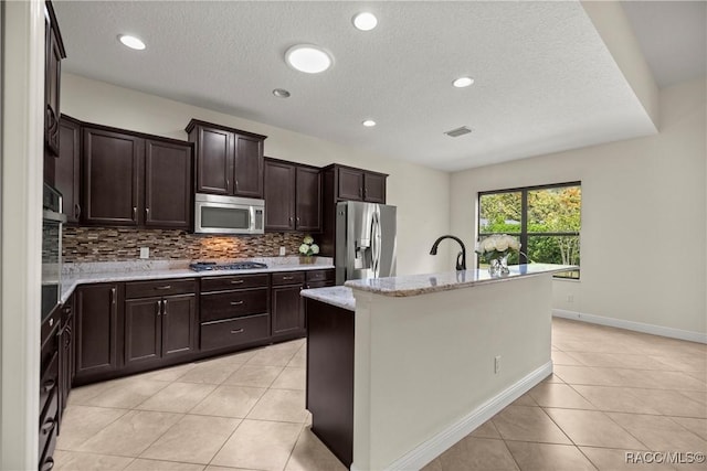 1825 W Caroline Path, Lecanto, FL 34461 - kitchen with appliances with stainless steel finishes, light tile patterned floors, tasteful backsplash, dark brown cabinetry, and a textured ceiling