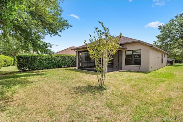 1825 W Caroline Path, Lecanto, FL 34461 - back of property featuring a sunroom, a lawn, and stucco siding