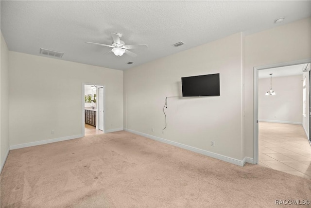 1825 W Caroline Path, Lecanto, FL 34461 - empty room with light carpet, ceiling fan, a textured ceiling, and light tile patterned floors