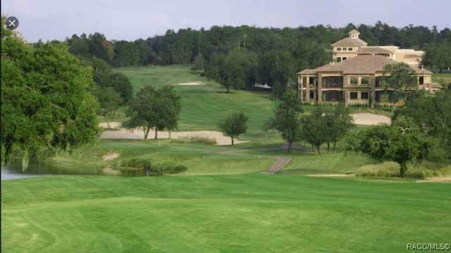 view of property's community with a lawn and a water view