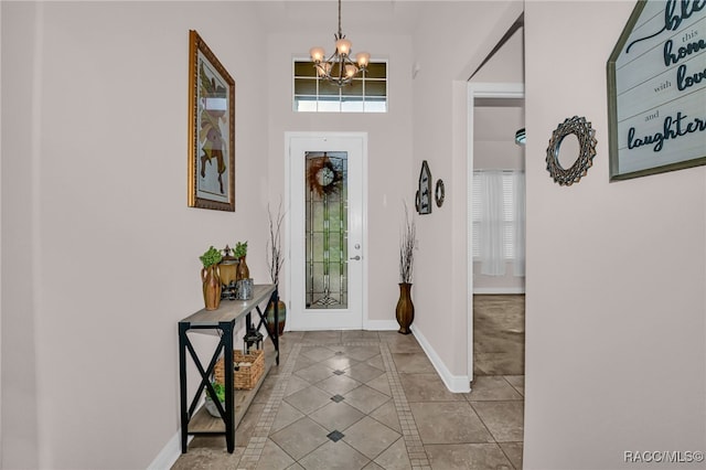 tiled entryway featuring a towering ceiling and a chandelier